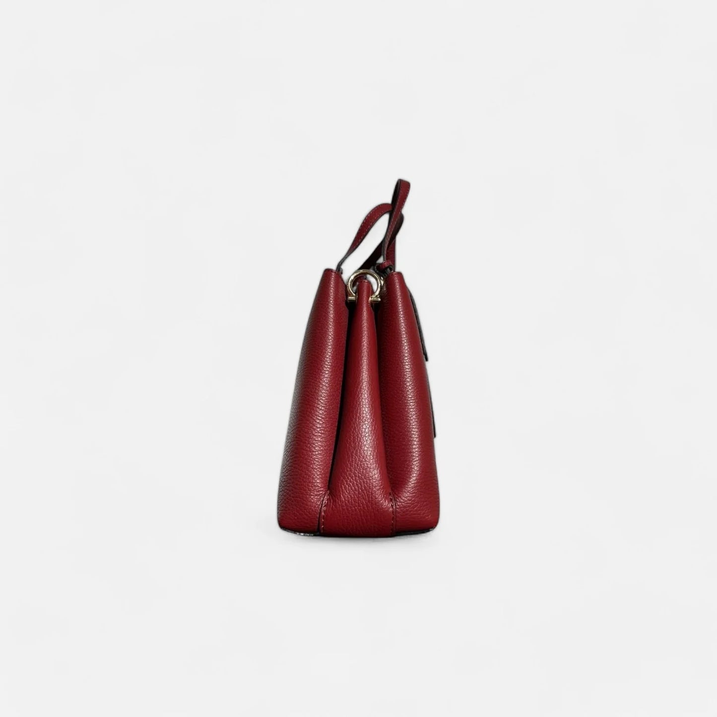 Vista lateral de bolso rojo de piel auténtica para mujer, con diseño estructurado y doble compartimento.