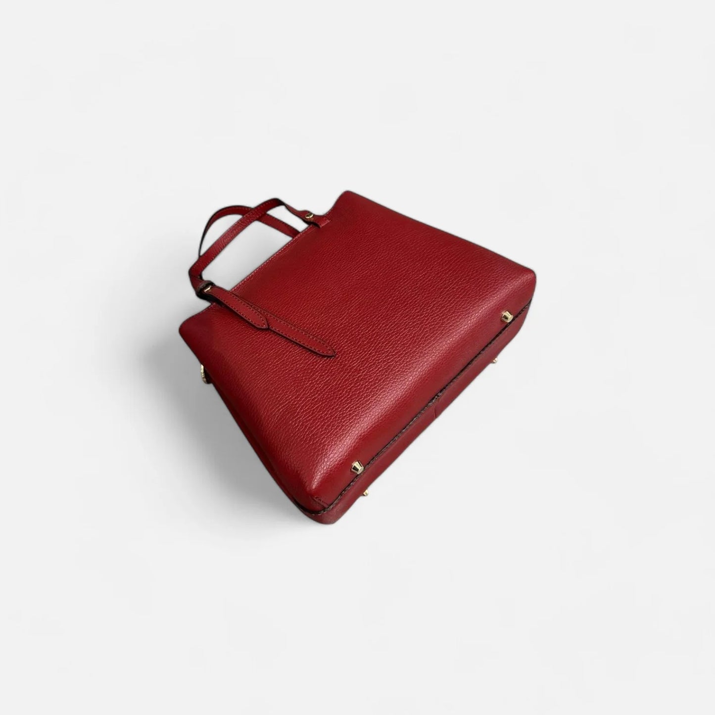 Bolso rojo de piel auténtica para mujer, vista inferior destacando su base reforzada con detalles metálicos.