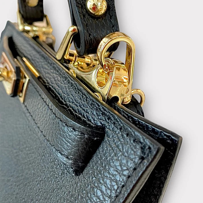 detalle bolso tote de piel negro, con correa extraible de cuero autentico. estilo new clasico. herrajes dorados