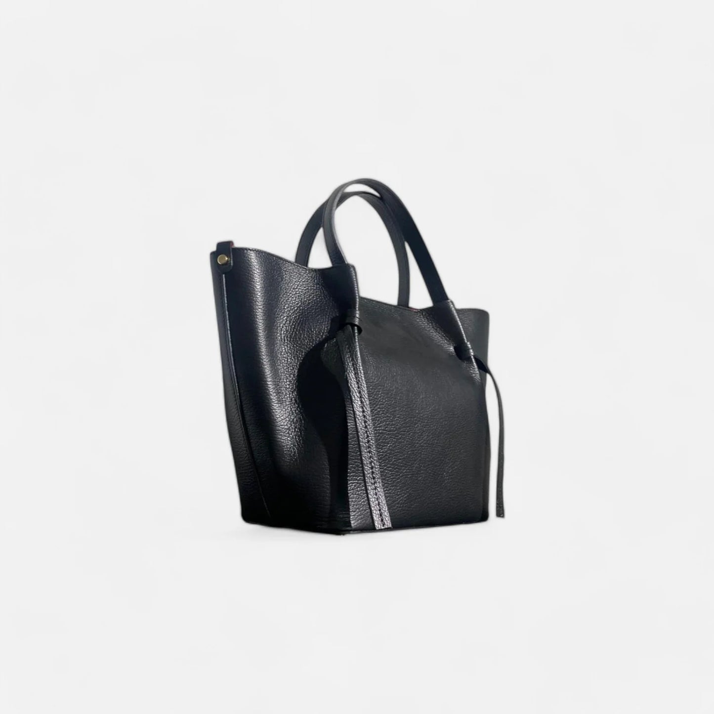 Bolso tote de cuero negro con interior rojo, asas y detalles de lazo lateral, comprar bolso de piel autentica barato
