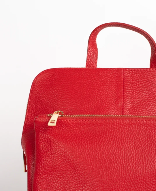 detalle cremallera color oro en mochila de piel roja. compralo online en nuestra tienda