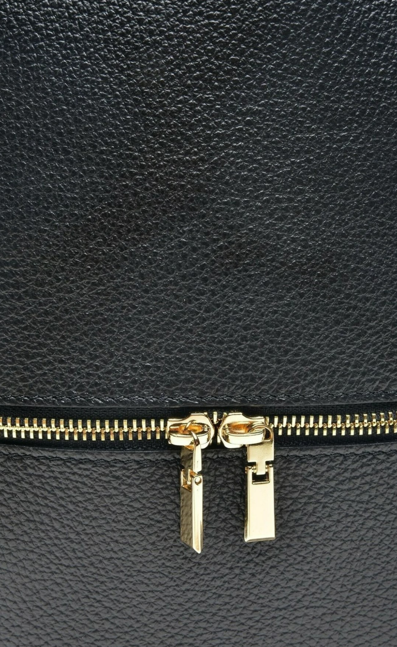 detalle de la piel de mochila de cuero negro y cremallera dorada