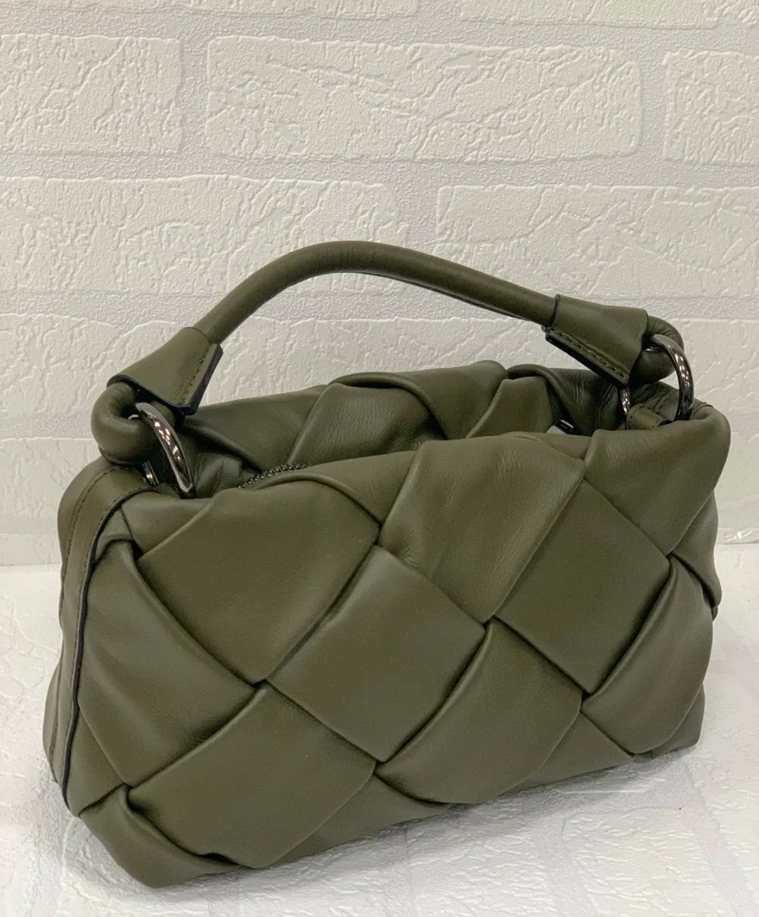 Bolso de piel verde trenzado para mujer. Diseño artesanal italiano con asa corta y detalles metálicos. Elegante y versátil. Comprar bolsos de piel online.