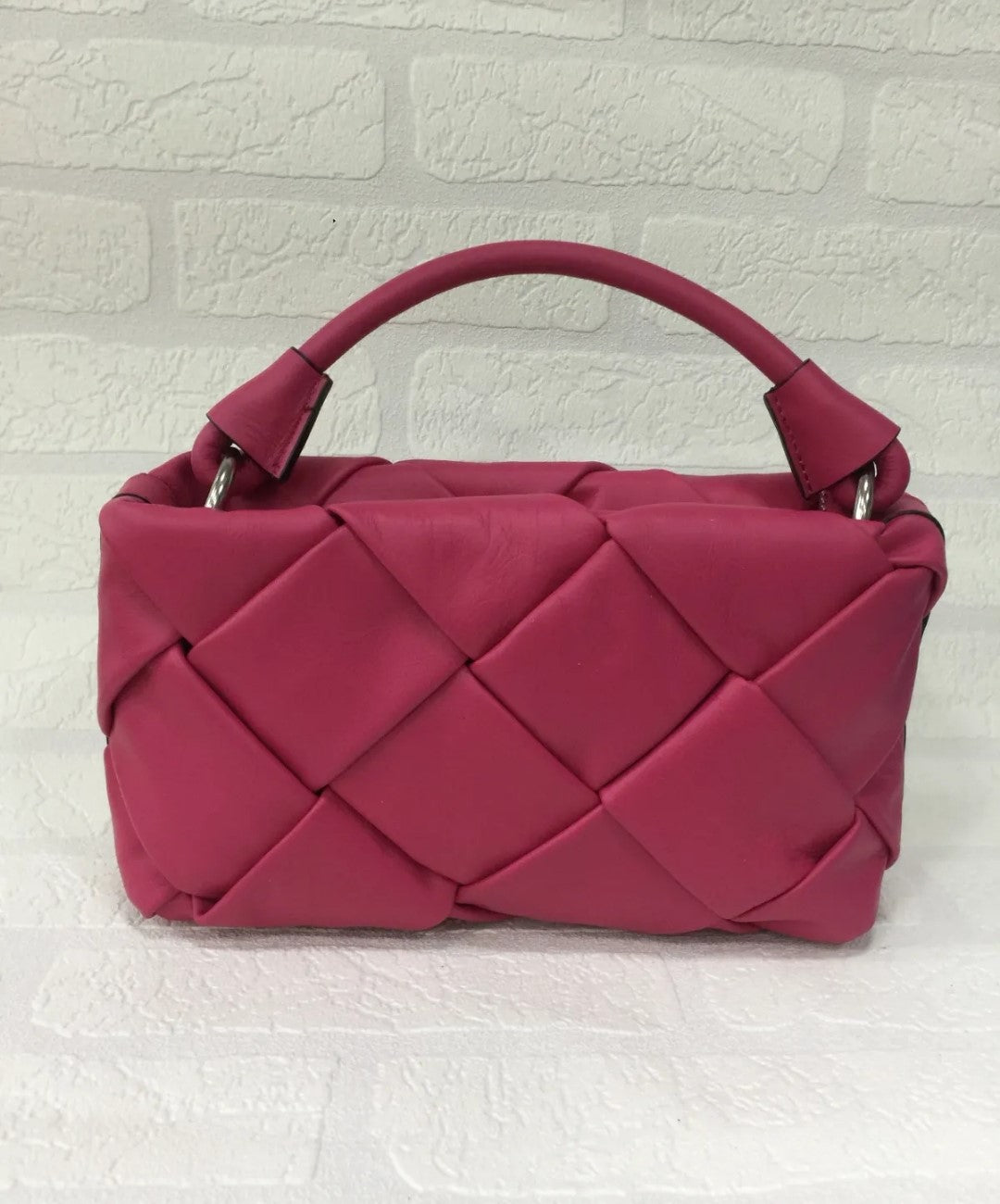 Bolso de piel rosa trenzado para mujer. Diseño elegante con asa corta y detalles metálicos. Ideal para cualquier ocasión. Comprar bolsos de piel exclusivos online.