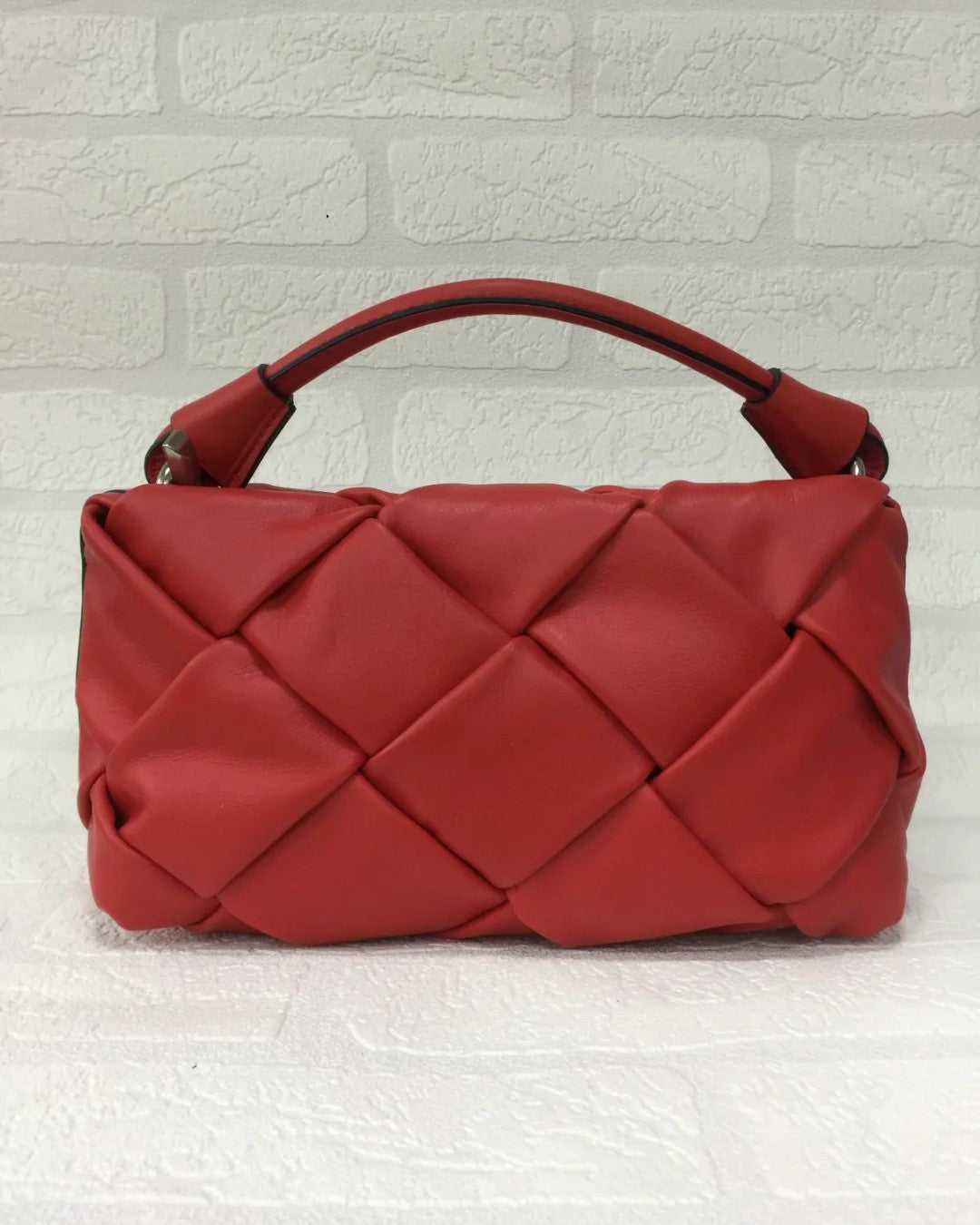 Bolso de piel roja trenzado para mujer. Diseño sofisticado con asa corta y detalles metálicos. Ideal para cualquier ocasión. Comprar bolsos de piel exclusivos online.