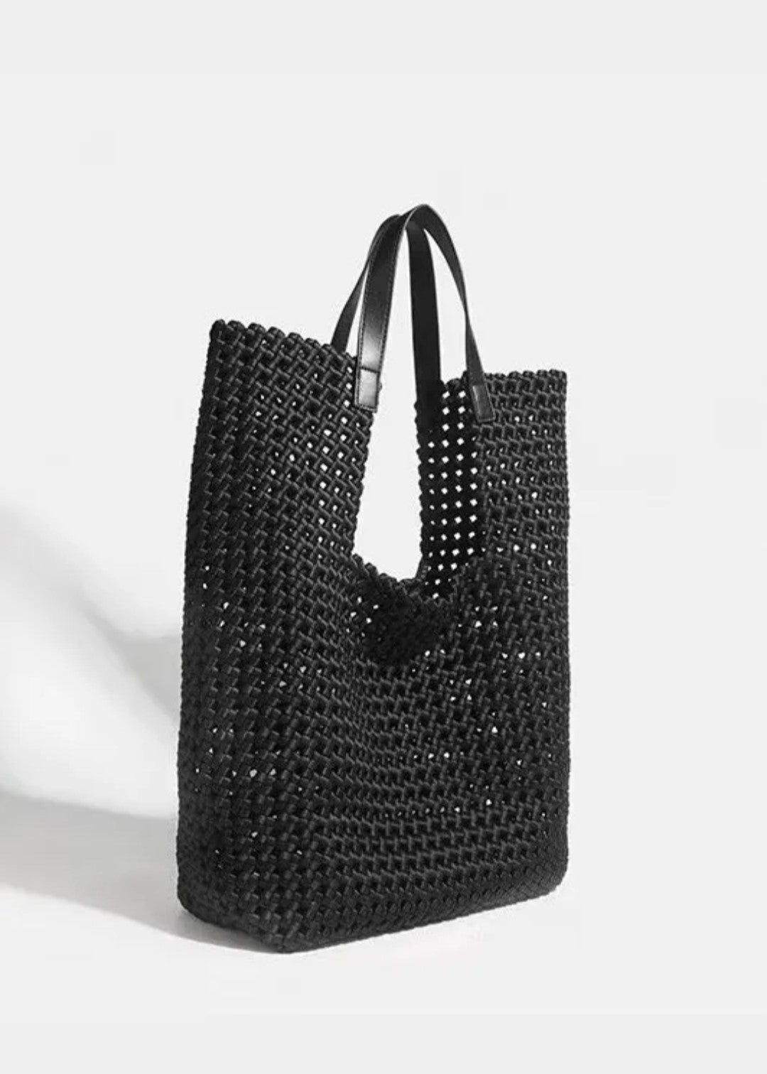 Bolso tote de piel negro con diseño tejido entrelazado y asas estructuradas. Espacioso, elegante y versátil para un look moderno.