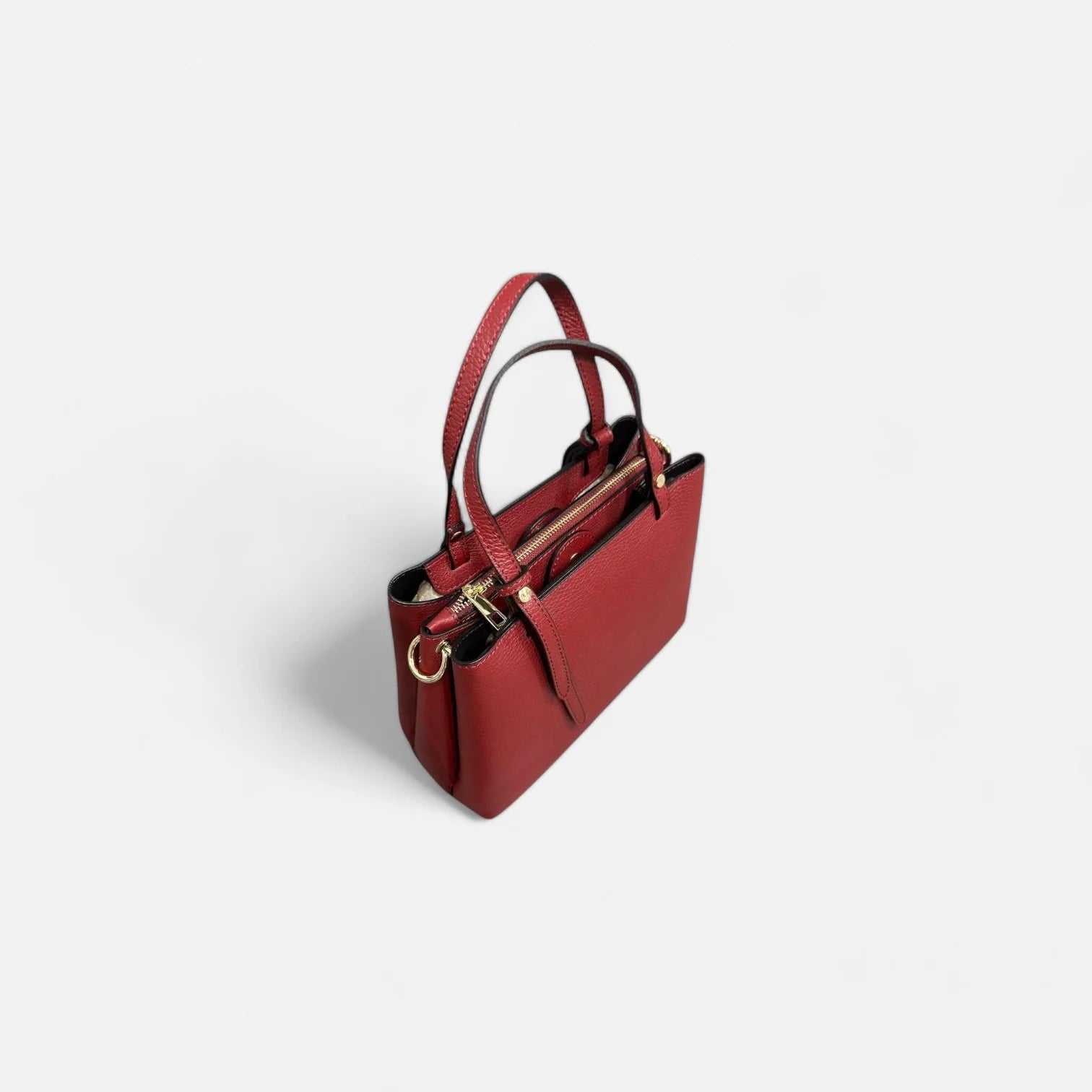 Bolso rojo de piel auténtica para mujer, vista superior mostrando su diseño con compartimentos espaciosos y cierre seguro.