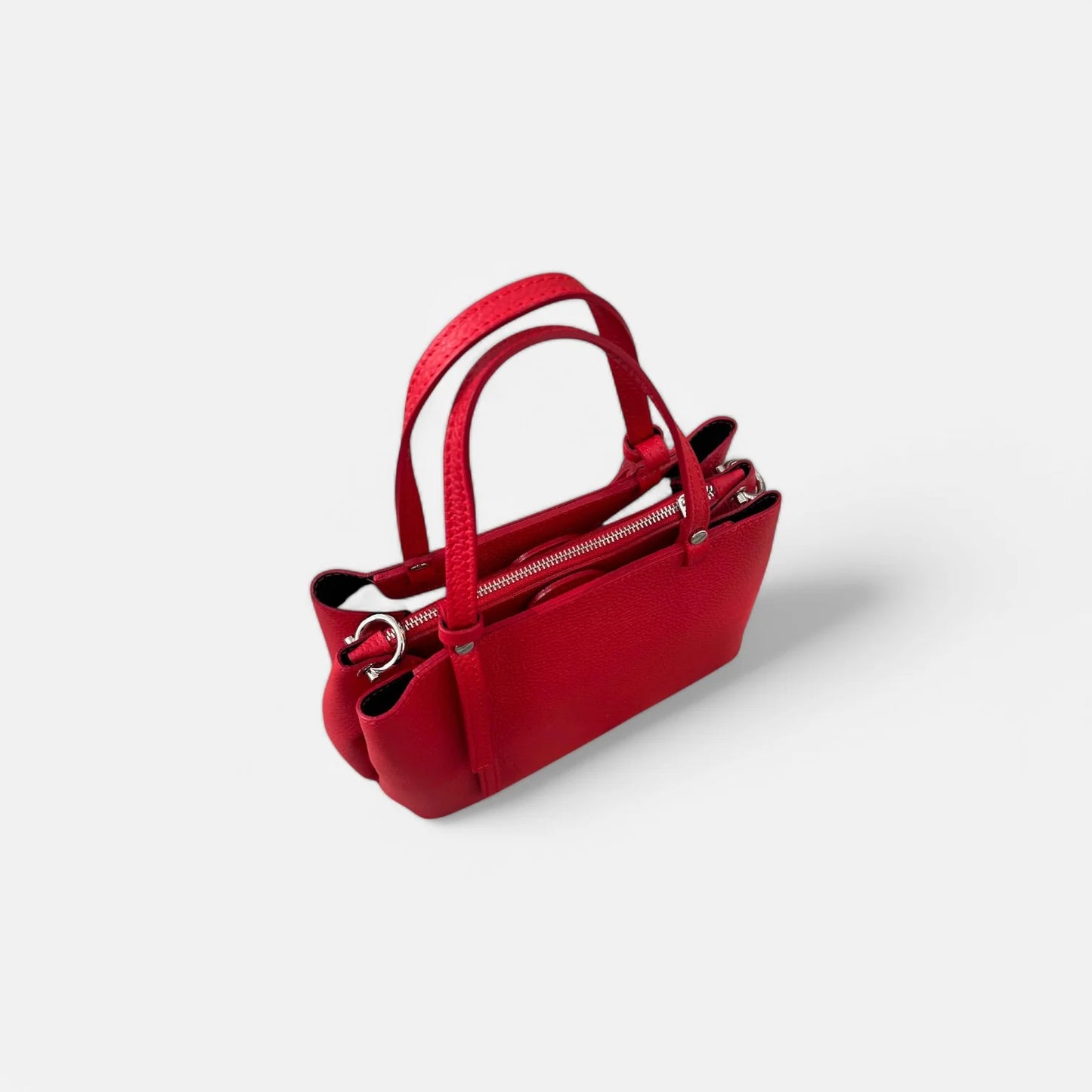 Bolso rojo de piel auténtica para mujer, vista superior mostrando su diseño compacto con doble compartimento y cierre de cremallera.